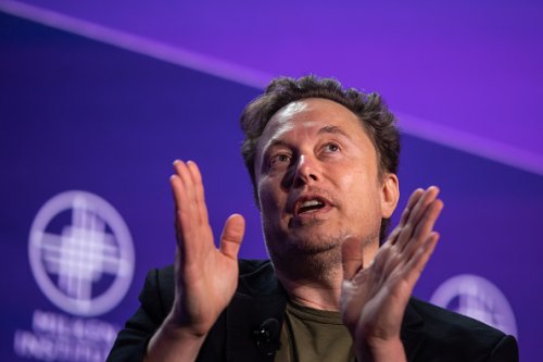 Left-Leaning Tesla Protesters Have Arranged A Circular Firing Squad Around An Elon Musk Hologram