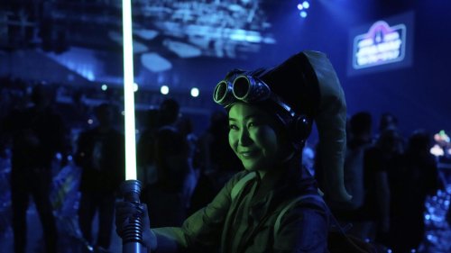 'Star Wars' fans wave lightsabers as an upcoming film gets announced in Japan