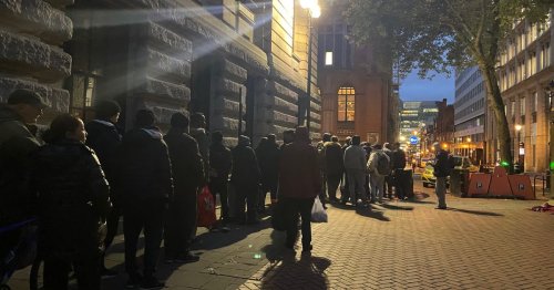 Hungry people queue for food in a side street close to the Conservative Party conference