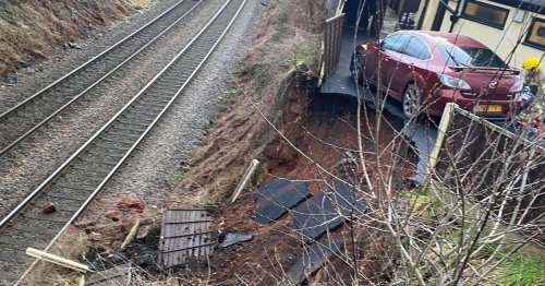 Train chaos as car teeters on bank edge after landslip blocks lines