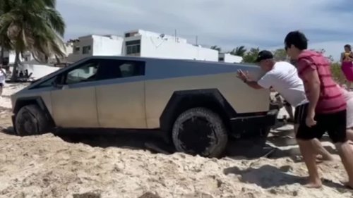 Im Sand festgefahren: Polizisten und Touristen müssen Tesla befreien
