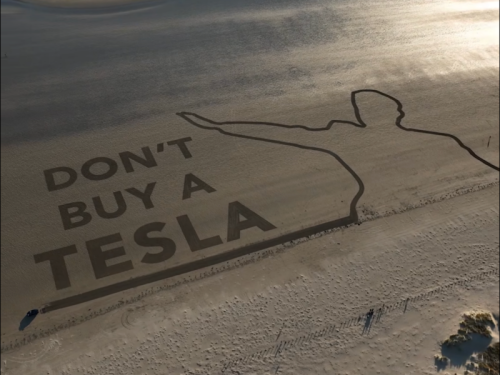 „Don’t buy a Tesla“: Aktivisten schreiben Botschaft mit einem Tesla in einen Strand in Wales