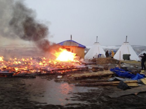 Most Dakota pipeline protesters leave as remnants of camp go up in flames