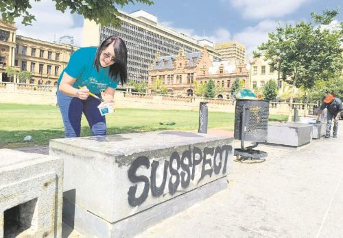 Volunteers scrape off graffiti, clean up iconic Church Square
