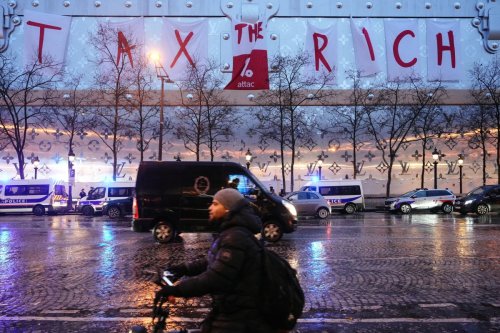 Paris : des militants d'Attac déploient une banderole géante sur le futur hôtel Vuitton des Champs-Élysées