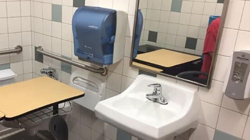 An autistic student needed a quiet place to work. His desk was put in a bathroom stall
