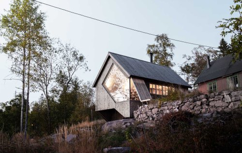 A Unique Window Shape Helps Frame The View From Inside This Cabin