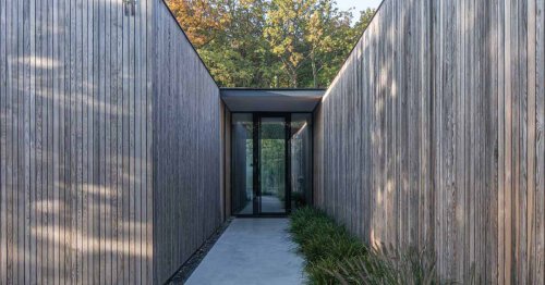 An Exterior Of Vertical Wood Siding Helps This House Blend Into The Surrounding Forest