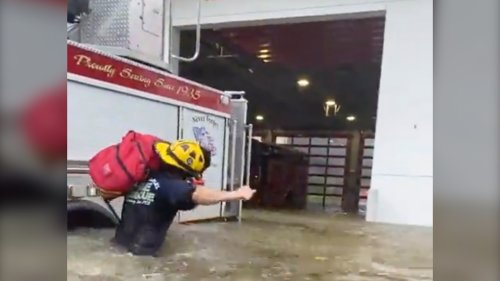 Firefighters in Florida push smoking fire truck through more than a metre of water as hurricane hits