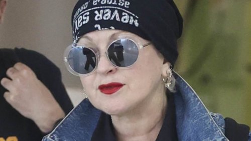 Iconic pop star, 71, looks unrecognisable in a double denim outfit at Sydney Airport - but can YOU guess who it is?