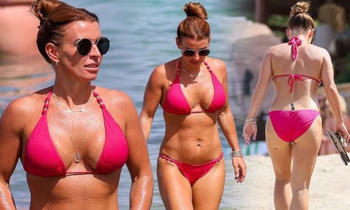 Coleen Rooney shows off her tanned and toned figure in a sizzling hot pink bikini as she enjoys an ocean dip during wild week in Ibiza with husband Wayne and pals