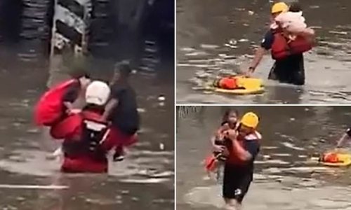Firefighters carry several children and a baby through chest-high flood waters in Denver after their minivan became submerged - amid historic rainfall across the West that devastated Death Valley in rare '1,000 year rainfall event'