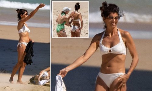 Matt Hancock's girlfriend Gina Coladangelo soaks up the sun in a white bikini while hitting the beach on Queensland's Gold Coast - as her partner makes it to the final four on I'm A Celeb