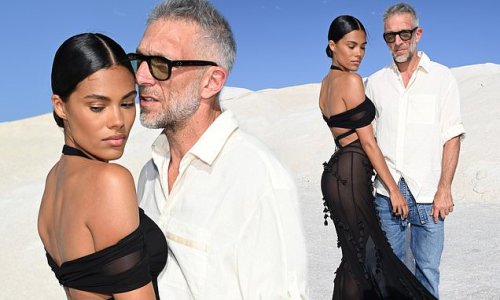 Tina Kunakey, 25, looks sensational as she poses in a backless sheer black dress with cut out detail while husband Vincent Cassel, 55, tenderly touches her hand at Le Papier Jacquemus' Fashion Show photocall