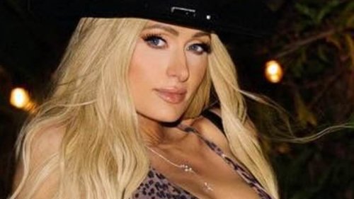 Paris Hilton, 43, shows off her toned figure in a leopard-print bikini and black hat as she parties...