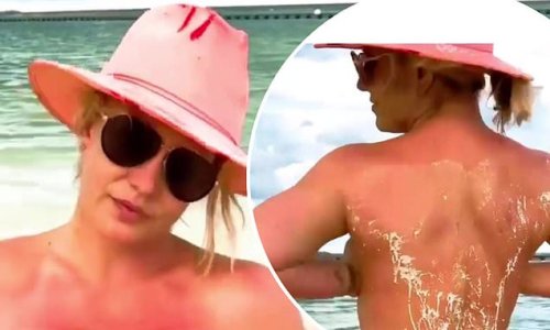 'I don't want to show it yet!' Topless Britney Spears strips down to a thong and pink cowboy hat on Maui beach as she teases she's cut 'all her hair off'