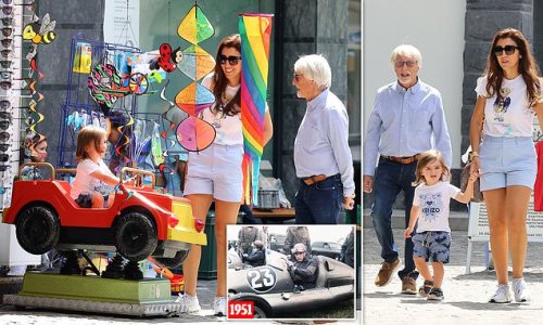 Formula fun! Bernie Ecclestone, 91, and his Brazilian wife Fabiana Flosi, 44, watch on as their two-year-old son Ace gets behind the wheel of an arcade ride during a family day out in Switzerland