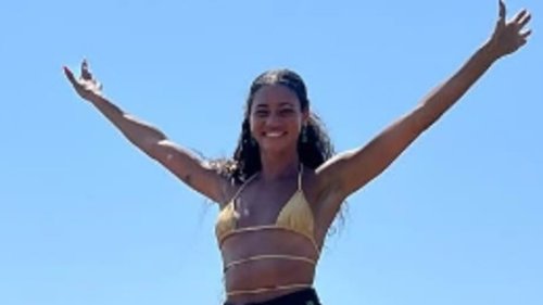 Vick Hope shows off her sensational figure in a yellow bikini and denim shorts while posing on a...