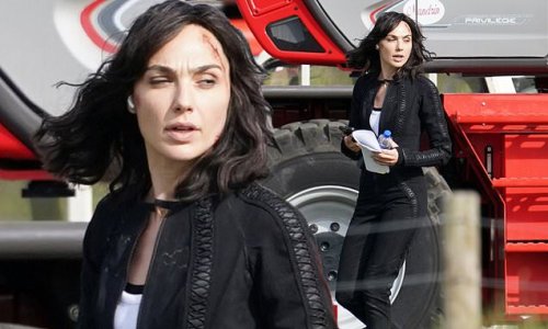 Gal Gadot cuts a casual figure in a black jumpsuit and sports a facial injury as she shoots scenes for spy film Heart Of Stone at an RAF museum
