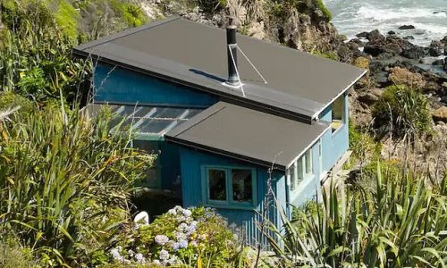 Travellers go wild for this 'perfect' retro beach house that's so close to the beach guests feel like they're sitting on top of the water: 'It's just magical'