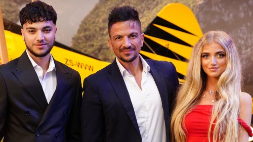 Princess Andre cuts a glamorous figure in a red gown as she attends the Mission: Impossible London premiere with brother Junior and dad Peter