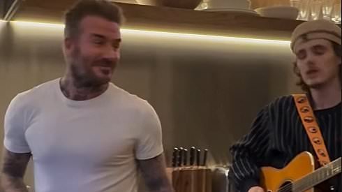 Cruz Beckham, 20, gets first gig of his fledgling music career at a family dinner - as he sings Islands In The Stream while his father David cooks up a storm