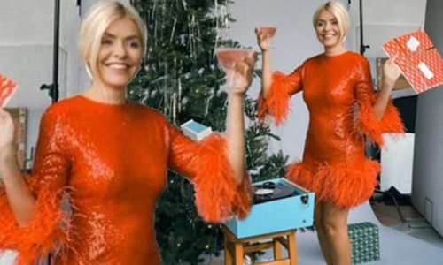 Holly Willoughby gets into the festive spirit as she puts on a leggy display in a sparkling red mini dress while posing beside a Christmas tree