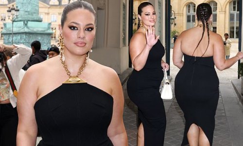 Ashley Graham shows off her eye-popping curves in a figure-hugging black dress and dons quirky gold toe heels as she attends the Schiaparelli show during Paris Fashion Week
