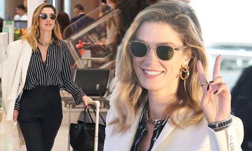 Delta Goodrem makes a stylish arrival at Sydney Airport in a white