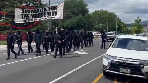 Watch the shocking moment dozens of masked Neo-Nazi protesters march down the main street of an...