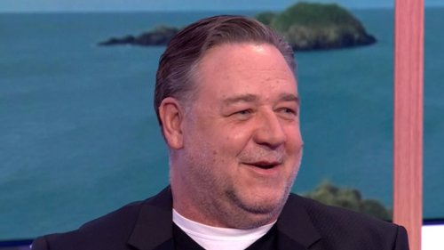 Russell Crowe shocks fans as he's mistaken for John Goodman during a TV appearance after debuting...