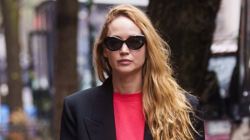 Jennifer Lawrence stands out in a red crewneck sweatshirt and black blazer as she carries a bright...