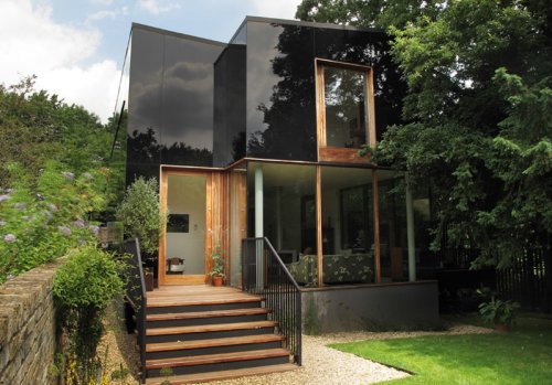 Striking Black Glass Home Mirrors Its Rich Surroundings