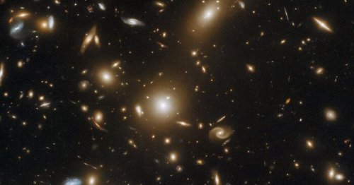 This galaxy cluster is so massive it warps space-time and bends light