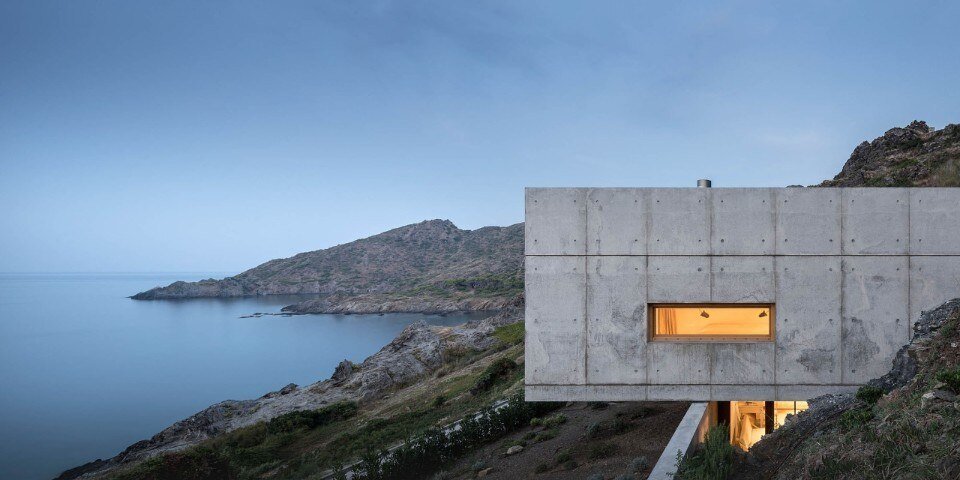 Una casa di cemento tra le rocce e il mare