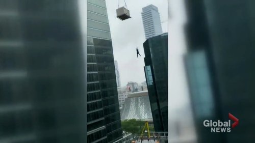 Caught on camera: Terrified construction worker dangles from crane in Toronto