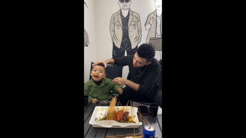 Father Feeds Kid Barbecue in a Distinctive Way in Yili,, China