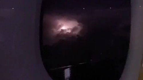 Emirates flight to Dubai encounters an electrifying light show over a storm-kissed night sky