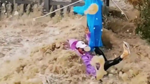 Massive tidal surge sweeps over riverbank - knocking over tourists
