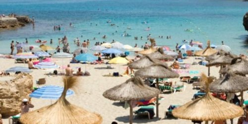 Urlauber stehen Schlange am Strand: Um das Klima zu schützen, will Mallorca weniger Touristen zulassen