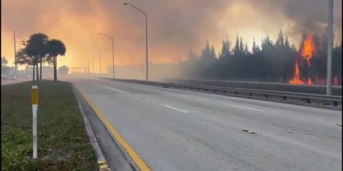 Watch: Grass fire flames rising in Miami send smoke onto road