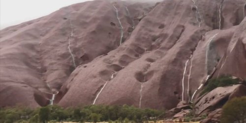 Uluru waterfalls appear after rain that 'hadn't been seen for a decade'