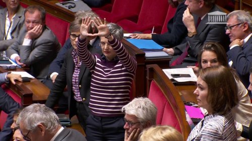 Violences faites aux femmes : Sandrine Rousseau forme un symbole féministe avec ses mains lors d'échanges à l'Assemblée nationale
