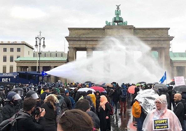 Police use water cannons at the Brandenburg Gate during a...