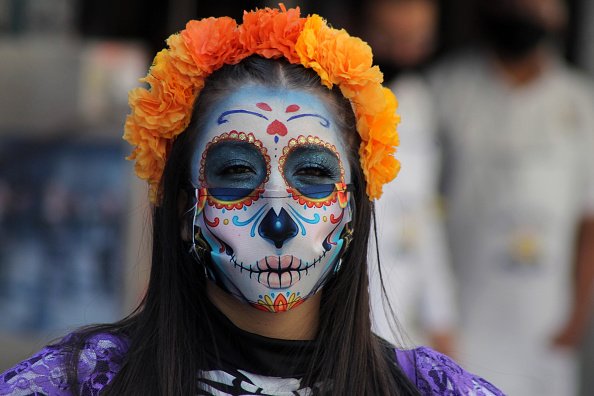A person with their face make-up as skull to celebrate the Mexican...
