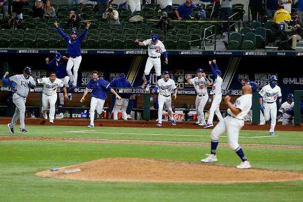 The Los Angeles Dodgers celebrate after Julio Urias strikes out Willy...