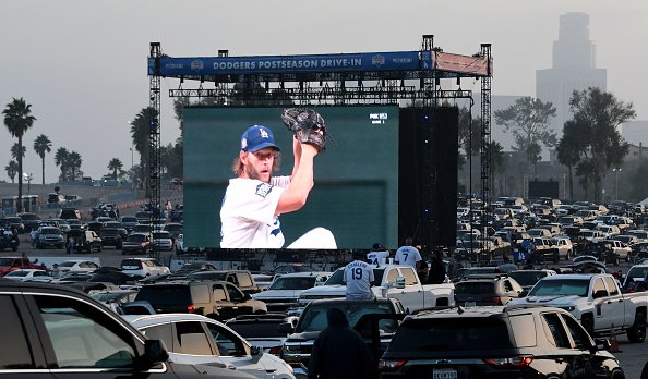 Clayton Kershaw of the Los Angeles Dodgers pitches as fans look on a...