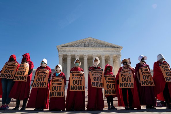 Dressed as handmaids, opponents of Supreme Court nominee Judge Amy...