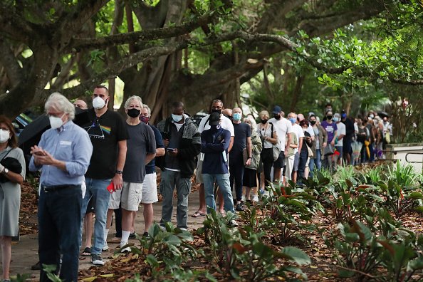 Voters wait in line to cast their early ballots at the Coral Gables...