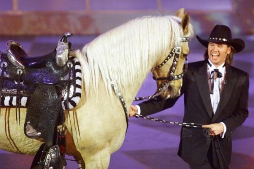 Actor Val Kilmer walks out with a horse after he introduced a special...